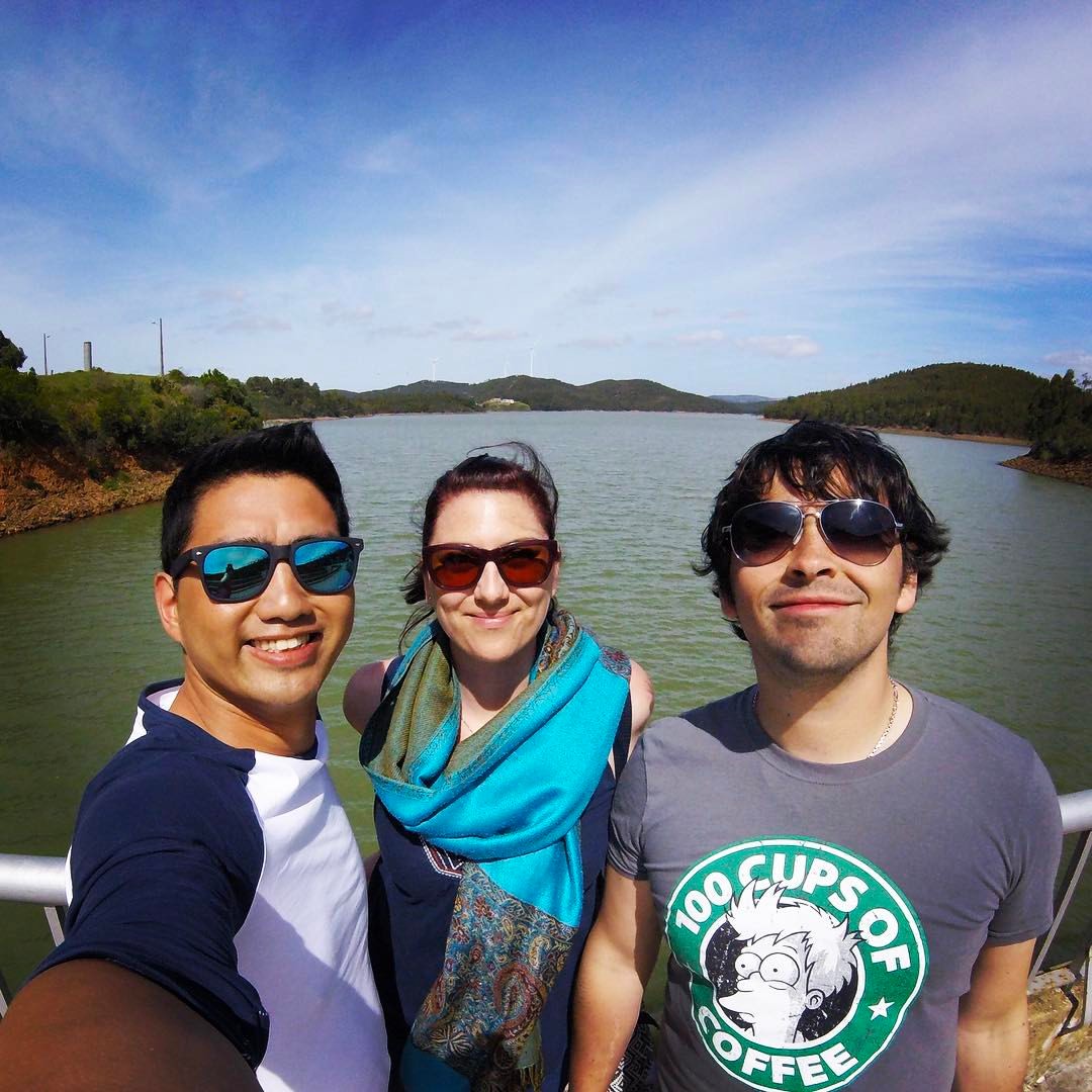 A picture of 3 friends by a reservoir